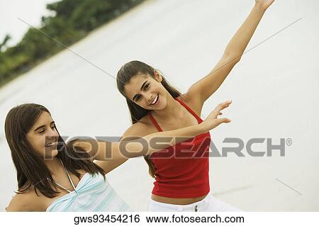 Stock Photograph - Close-up of two girls dancing on the beach. Fotosearch
