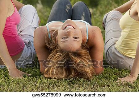 Stock Photo - Close-up of two mid adult women with a mature woman in a park. Fotosearch