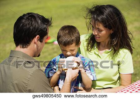Stock Image - Father feeding bread to his son. Fotosearch