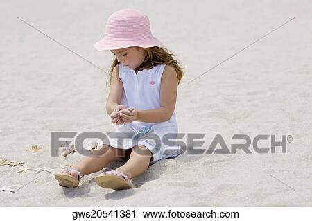 Girl sitting near a starfish and seashells on the beach View Large Photo Image Stock Image - Girl sitting near a starfish and seashells on the beach. Fotosearch