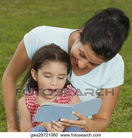 Girl sitting on her mother's lap and reading a book View Large Photo Image Stock Image - Girl sitting on her mother's lap and reading a book. Fotosearch
