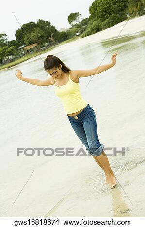 Girl standing in a lake with her arms outstretched View Large Photo Image Picture - Girl standing in a lake with her arms outstretched. Fotosearch