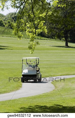 Golf cart on a path in a golf course View Large Photo Image Stock Image - Golf cart on a path in a golf course. Fotosearch