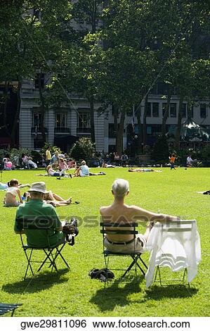 Stock Photograph - Group of people sunbathing in a park. Fotosearch