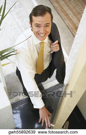 Stock Photo - High angle view of a businessman opening a door. Fotosearch