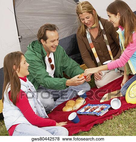High angle view of a girl giving an apple to her father with her mother and sister sitting beside them View Large Photo Image Stock Photo - High angle view of a girl giving an apple to her father with her mother and sister sitting beside them. Fotosearch