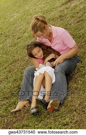 High angle view of a mature woman and her daughter reading a book in the park View Large Photo Image Stock Image - High angle view of a mature woman and her daughter reading a book in the park. Fotosearch