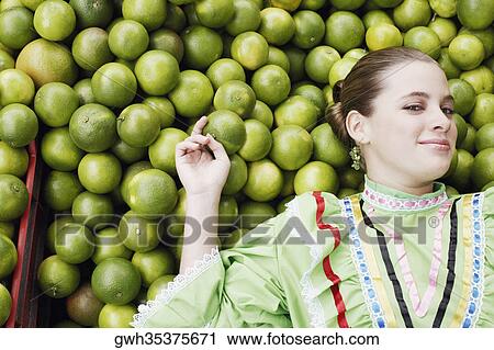 High angle view of a young woman lying on a heap of tangerines View Large Photo Image Stock Image - High angle view of a young woman lying on a heap of tangerines. Fotosearch