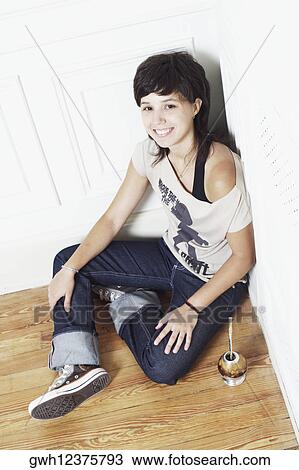High angle view of a young woman sitting on the floor at the corner of a room View Large Photo Image Stock Image - High angle view of a young woman sitting on the floor at the corner of a room. Fotosearch