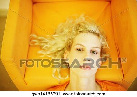 High angle view of a young woman resting her head on an armchair View Large Photo Image Stock Image - High angle view of a young woman resting her head on an armchair. Fotosearch