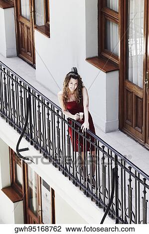 High angle view of a young woman standing in the balcony View Large Photo Image Stock Image - High angle view of a young woman standing in the balcony . Fotosearch