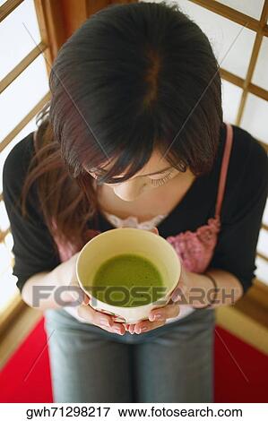 High angle view of a young woman holding a bowl of herbal tea View Large Photo Image Stock Photo - High angle view of a young woman holding a bowl of herbal tea. Fotosearch
