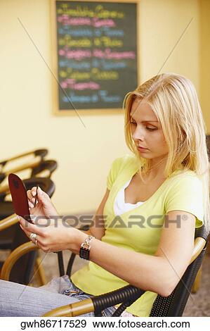 High angle view of a young woman holding a personal data assistant View Large Photo Image Stock Photo - High angle view of a young woman holding a personal data assistant . Fotosearch