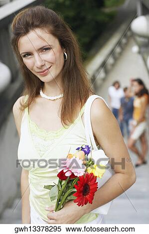 High angle view of a young woman holding a bouquet of flowers View Large Photo Image Stock Photography - High angle view of a young woman holding a bouquet of flowers . Fotosearch