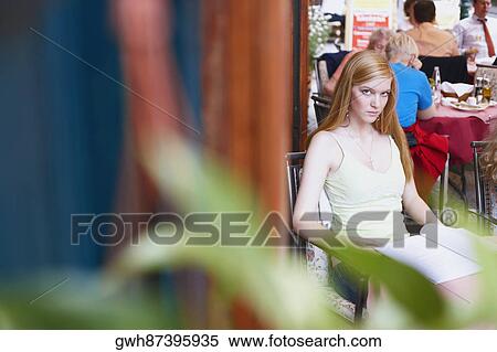 Stock Photography - High angle view of a young woman sitting in a cafe . Fotosearch