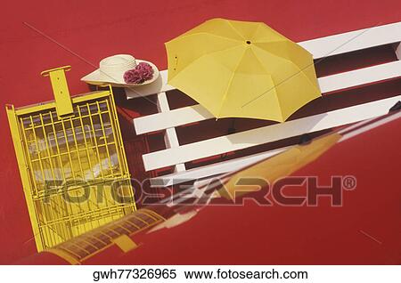 Stock Photography - High angle view of an umbrella on a bench. Fotosearch