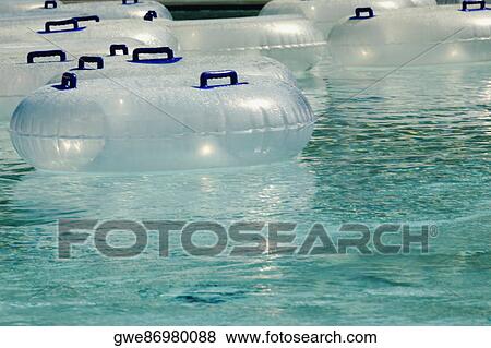 Stock Photo - Inflatable rings floating in a pool. Fotosearch