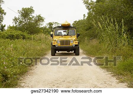 Jeep on a dirt road with a kayak on its roof View Large Photo Image Stock Image - Jeep on a dirt road with a kayak on its roof. Fotosearch
