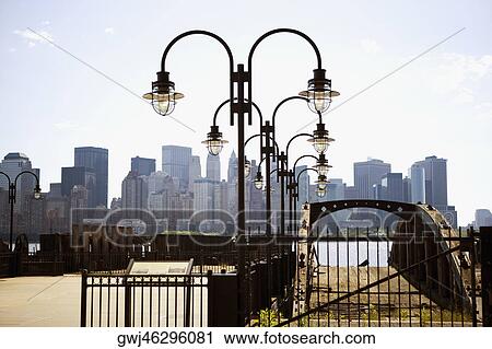Lamppost in the park with buildings in the background, Manhattan, New York City, New York State, USA View Large Photo Image Stock Image - Lamppost in the park with buildings in the background, Manhattan, New York City, New York State, USA. Fotosearch