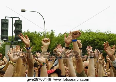 Stock Photo - Large group of people waving their arms at a gay parade. Fotosearch