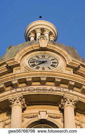 Stock Photo - Low angle view of a building with a clock and carved panels. Fotosearch