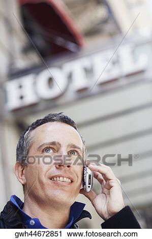 Low angle view of a mature man talking on a mobile phone View Large Photo Image Stock Image - Low angle view of a mature man talking on a mobile phone . Fotosearch