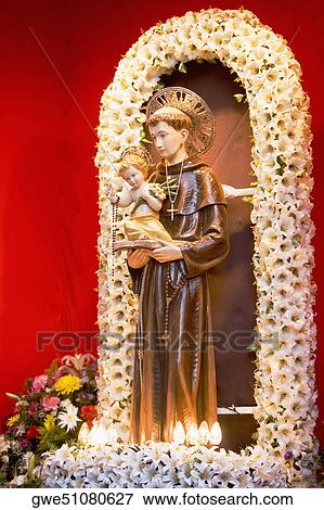 Stock Photo - Low angle view of a statue of St. Anthony with baby Jesus. Fotosearch