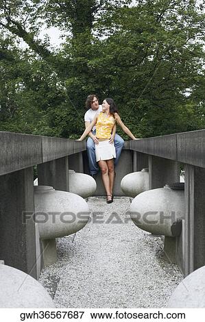 Stock Photo - Low angle view of a young couple in a park . Fotosearch