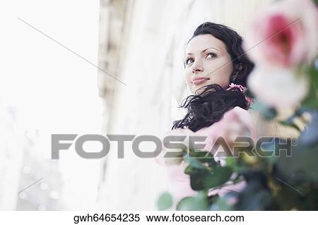 Low angle view of a young woman grinning View Large Photo Image Stock Photography - Low angle view of a young woman grinning. Fotosearch