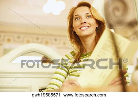 Low angle view of a young woman holding a menu card View Large Photo Image Stock Image - Low angle view of a young woman holding a menu card . Fotosearch