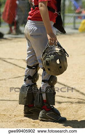 Low section view of a baseball catcher holding a helmet View Large Photo Image Stock Image - Low section view of a baseball catcher holding a helmet. Fotosearch