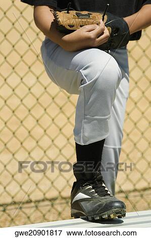 Stock Photo - Low section view of a baseball player standing in a baseball field. Fotosearch