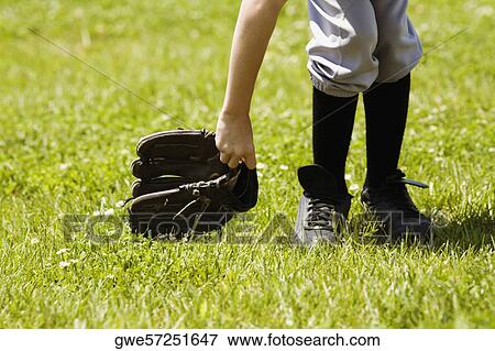 Stock Photo - Low section view of a baseball player holding a baseball glove. Fotosearch