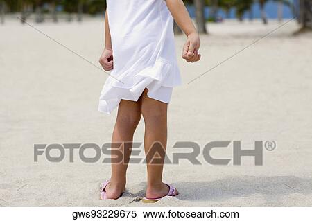 Low section view of a girl standing on the beach View Large Photo Image Stock Photography - Low section view of a girl standing on the beach. Fotosearch
