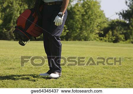 Stock Photo - Low section view of a man carrying a golf bag. Fotosearch