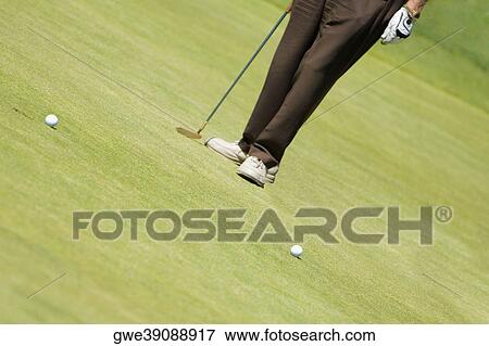 Low section view of a man holding a golf club on a golf course View Large Photo Image Stock Photo - Low section view of a man holding a golf club on a golf course. Fotosearch