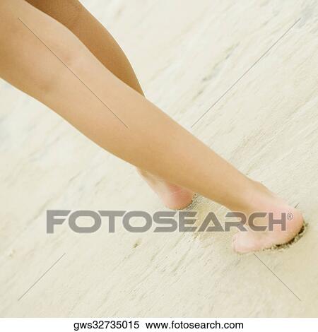 Low section view of a person walking on sand View Large Photo Image Stock Photography - Low section view of a person walking on sand. Fotosearch