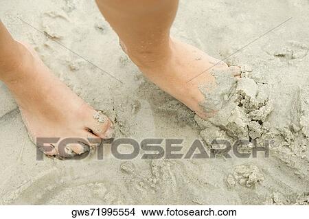Low section view of a person's foot in sand View Large Photo Image Picture - Low section view of a person's foot in sand. Fotosearch