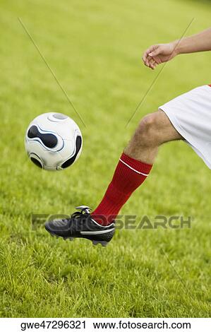 Low section view of a soccer player kicking a soccer ball View Large Photo Image Stock Image - Low section view of a soccer player kicking a soccer ball. Fotosearch