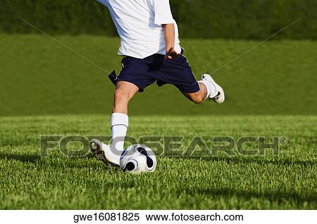 Stock Photography - Low section view of a soccer player playing soccer. Fotosearch