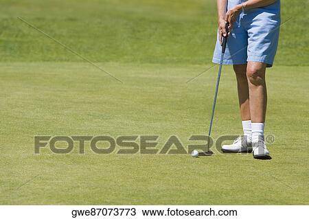 Low section view of a woman holding a golf club on a golf course View Large Photo Image Stock Image - Low section view of a woman holding a golf club on a golf course. Fotosearch