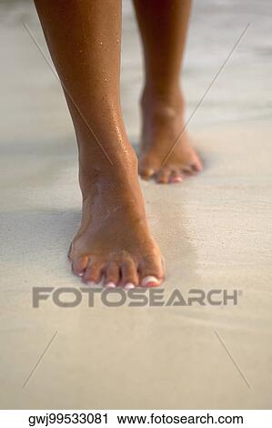 Low section view of a woman walking on the beach View Large Photo Image Stock Image - Low section view of a woman walking on the beach. Fotosearch