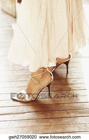 Stock Image - Low section view of a woman wearing high heels. Fotosearch