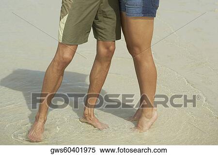 Low section view of a young man and a teenage girl standing on the beach View Large Photo Image Stock Photography - Low section view of a young man and a teenage girl standing on the beach. Fotosearch