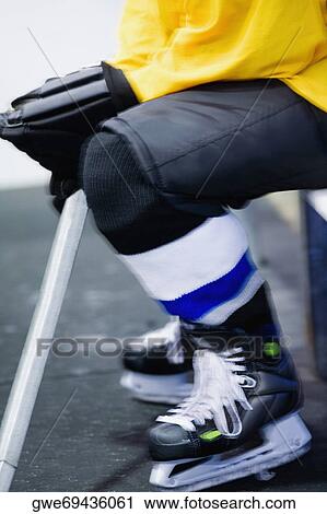 Stock Image - Low section view of an ice hockey player in a uniform. Fotosearch