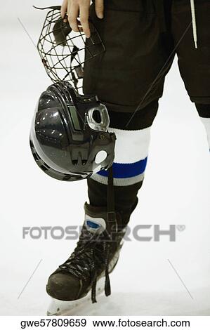 Low section view of an ice hockey player holding a helmet View Large Photo Image Stock Photo - Low section view of an ice hockey player holding a helmet. Fotosearch