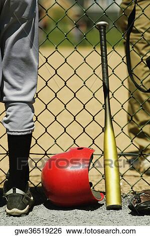 Stock Photograph - Low section view of two boys standing on either sides of a chain-link fence. Fotosearch