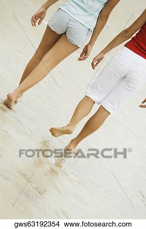 Low section view of two people walking on the beach View Large Photo Image Picture - Low section view of two people walking on the beach. Fotosearch