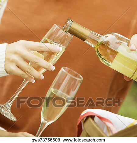 Man pouring champagne into a champagne flute View Large Photo Image Stock Photo - Man pouring champagne into a champagne flute. Fotosearch