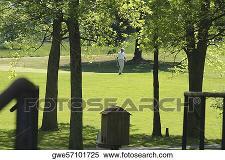 Stock Photography - Man walking on a golf course. Fotosearch